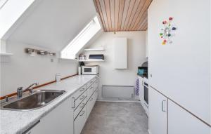 una cocina con armarios blancos y fregadero en Nice Home In Assens With House Sea View, en Assens