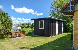 a black and white shed with a picnic table in a yard at 2 Bedroom Gorgeous Home In Nrre Nebel in Nymindegab