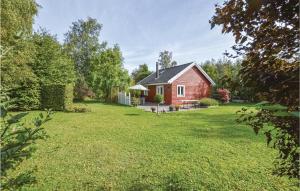 una casa roja en un patio con césped en Beautiful Home In Kalundborg With Kitchen, en Kalundborg