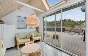 un soggiorno con tavolo e sedie e un patio di Three-Bedroom Holiday Home In Hvide Sande a Bjerregård