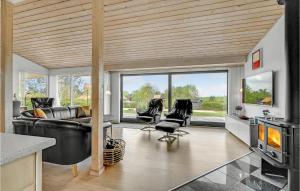 KnebelにあるStunning Home In Knebel With 4 Bedrooms, Sauna And Wifiのリビングルーム(黒い革張りのソファ、椅子付)