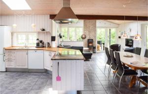 a kitchen with white cabinets and a table with chairs at 4 Bedroom Cozy Home In Tranekr in Hou