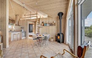 a kitchen and dining room with a table and a stove at Holiday Home Svenstibakkevej Denmark I in Lild Strand +17 photos