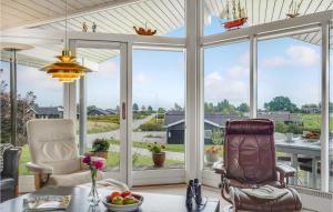 a screened in porch with two chairs and a table at Holiday Home Skovridervænget Denm in Spodsbjerg