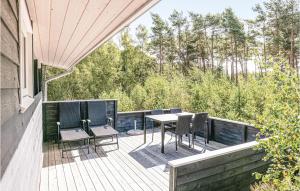 a deck with chairs and a table on a house at Nice Home In Nex With 2 Bedrooms And Wifi in Bedegård