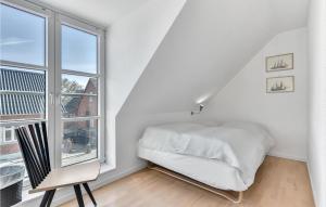 een witte slaapkamer met een bed en een raam bij Gorgeous Home In Tranekr With Kitchen in Tranekær