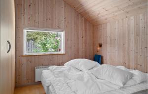 KramnitseにあるBeautiful Home In Rdby With 4 Bedrooms, Sauna And Wifiの木製の壁に白いベッドが備わるベッドルーム1室