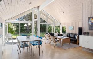 a dining room and living room with a table and chairs at Holiday Home Mågelunden Rødby Ii in Kramnitse