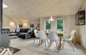 a living room with a table and white chairs at Amazing Home In Vggerlse With 4 Bedrooms, Sauna And Wifi in Bøtø By