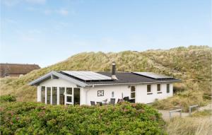HavrvigにあるNice Home In Hvide Sande With Kitchenの丘の上に設置されたソーラーパネル付きの家