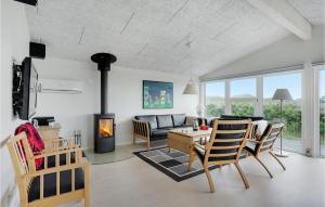 a living room with a couch and a fireplace at Nice Home In Hvide Sande With Kitchen in Havrvig