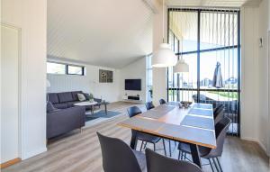 comedor y sala de estar con mesa y sillas en Lovely Home In Juelsminde With House Sea View, en Sønderby