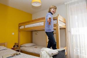 a young child jumping on top of bunk beds at VVF La Plagne Montchavin Paradiski in Bellentre