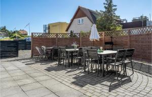 a patio with tables and chairs and a fence at Stunning Home In Nrre Nebel With Wifi in Nymindegab