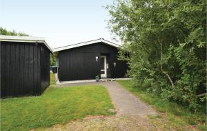 a black shed with a pathway in front of it at Amazing Home In Fan With 3 Bedrooms And Wifi in Fanø