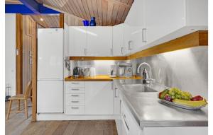 a kitchen with white cabinets and a bowl of fruit on the counter at Awesome Home In Vig With Sauna in Vig +29 photos