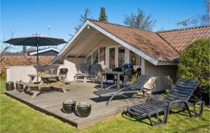 una terraza de madera con sillas, mesa y sombrilla en Amazing Home In Dronningmlle With Wifi, en Dronningmølle