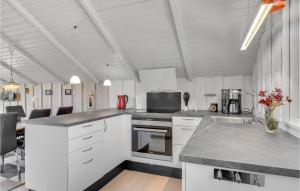 a kitchen with white cabinets and a counter top at Holiday Home Gøgevej Dronningmølle Vi in Dronningmølle