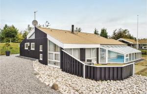 a black house on a pile of rocks at Stunning Home In Ebeltoft With 4 Bedrooms, Private Swimming Pool And Indoor Swimming Pool in Ebeltoft