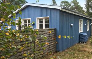 una casa azul con una valla delante de ella en Nice Home In Nex With Wifi en Balke