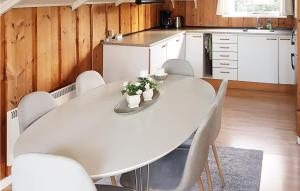 uma mesa branca numa cozinha com cadeiras brancas em Nice Home In Vggerlse With Wifi em Bøtø By
