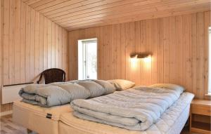 ヘアニングにある3 Bedroom Stunning Home In Herningの木製の壁の客室の大型ベッド1台