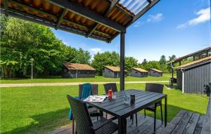 einen Holztisch und Stühle auf einer Terrasse in der Unterkunft Gorgeous Home In Hampen With Wifi in Hampen