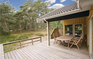 a wooden deck with a table and chairs on it at Four-Bedroom Holiday Home In Nexo in Vester Sømarken