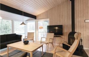 a living room with a couch and a table and a fireplace at Lovely Home In Nex With Sauna in Vester Sømarken