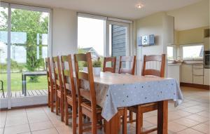 a dining room with a table and chairs and a kitchen at Nice Home In Skjern With Wifi in Lem