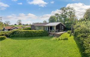 a small house in a field with a yard at Beautiful Home In Tranekr With 3 Bedrooms And Wifi in Lokkeby