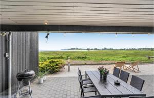DiernæsにあるStunning Home In Haderslev With Wifiの海の景色を望むパティオ(テーブル、椅子付)