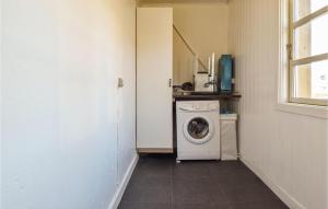 a laundry room with a washing machine and a window at Nice Home In Frrup With Kitchen in Frørup