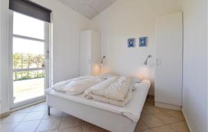 オテルプにあるAmazing Home In Otterup With Saunaの白いベッドルーム(ベッド1台、大きな窓付)