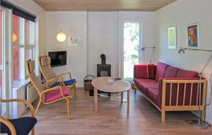 uma sala de estar com um sofá roxo e cadeiras em 3 Bedroom Nice Home In Aakirkeby em Vester Sømarken