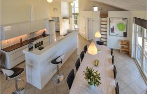 オテルプにあるAmazing Home In Otterup With Saunaのテーブルと椅子、キッチンが備わる客室です。