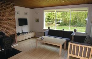 uma sala de estar com um sofá e uma televisão em Pari em Rønne
