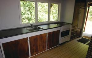uma cozinha com um lavatório e duas janelas em Pari em Rønne