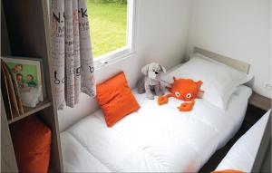 una pequeña cama con dos animales de peluche sentados en ella en Pet Friendly Home In Hvide Sande With Indoor Swimming Pool, en Hvide Sande