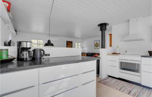 una cocina blanca con armarios y electrodomésticos blancos en 3 Bedroom Awesome Home In Hadsund, en Hadsund
