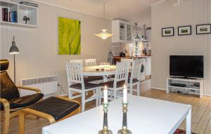 Vester Sømarken的住宿－3 Bedroom Pet Friendly Home In Aakirkeby，厨房以及带桌椅的起居室。