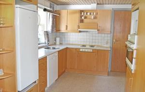 een kleine keuken met houten kasten en een wastafel bij Gorgeous Home In Rm With Sauna in Rømø Kirkeby