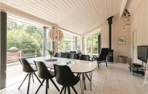 Vester SømarkenにあるBeautiful Home In Aakirkeby With 3 Bedrooms And Wifiのリビングルーム(テーブル、椅子付)