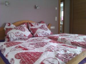 1 cama con almohadas y mantas rojas y blancas en Appartement Angertal, en Bad Hofgastein