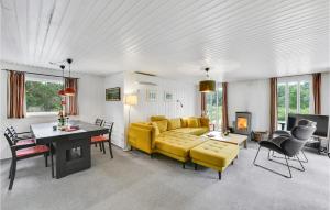 BjerregårdにあるCozy Home In Hvide Sande With Kitchenのリビングルーム(黄色のソファ、テーブル付)