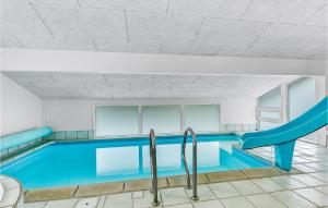 een zwembad met een glijbaan in een gebouw bij Lovely Home In Sydals With Indoor Swimming Pool in Høruphav
