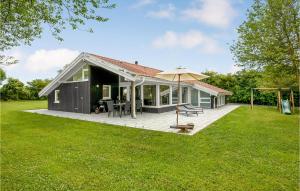 een huis met een terras en een paraplu bij Lovely Home In Sydals With Indoor Swimming Pool in Høruphav