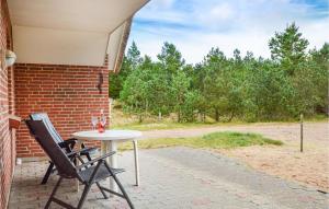 a table and two chairs sitting on a patio at Holiday Home Rømø 60 in Rømø Kirkeby +22 photos
