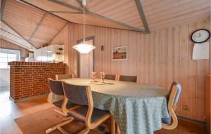 a dining room with a table with chairs and a clock at Holiday Home Rømø 60 in Rømø