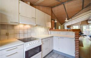 uma cozinha com electrodomésticos brancos e tectos em madeira em Amazing Home In Rm With Sauna em Rømø Kirkeby